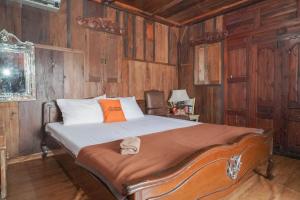a bedroom with a large bed with wooden walls at KoolKost Syariah near Senayan City in Jakarta