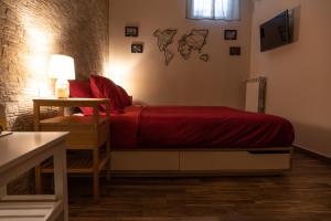 a bedroom with a bed with a red comforter at Tizzy Apartment & Rooms in Bari