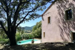 una casa con piscina junto a un árbol en A Maestra, en Sartène