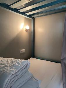 a bed in a room with a light on the wall at Hostel Umbrella in Tallinn