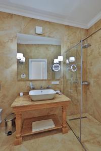 La salle de bains est pourvue d'un lavabo et d'une douche. dans l'établissement Dynasty Hotel, à Gelendzhik
