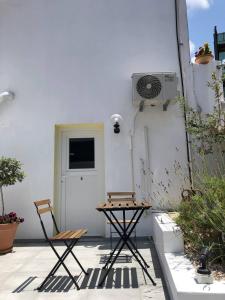 eine Terrasse mit 2 Stühlen, einem Tisch und einer Tür in der Unterkunft Katsikantaris Homes in Paphos City