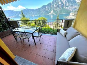 un soggiorno con divano e un tavolo sul balcone. di appartamento con bellissima vista a Campione dʼItalia