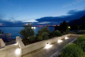 eine Terrasse mit Blick auf das Wasser in der Nacht in der Unterkunft Residence Visković in Tučepi