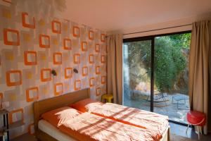 1 dormitorio con cama y ventana grande en Bel Appart Style Vintage Vue Mer, en La Londe-les-Maures