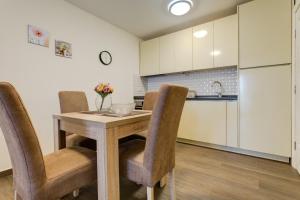 a kitchen with a wooden table and chairs at Apartments Horizont in Budva