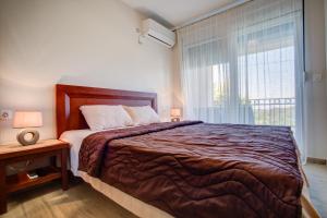 a bedroom with a large bed and a window at Apartments Horizont in Budva