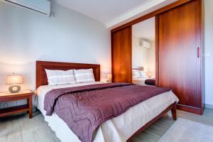 a bedroom with a large bed with a wooden headboard at Apartments Horizont in Budva