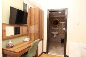 a room with a desk with a television and a toilet at Buldum Otel in Ankara +103 photos