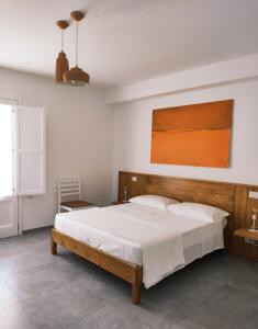 una camera con un grande letto con testiera in legno di A est b&b Otranto a Otranto