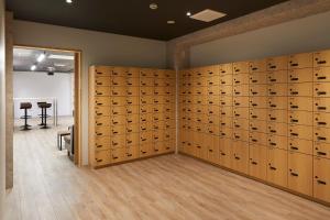 大阪hotel atarayo osaka的一张桌子的房间里,墙上挂着储物柜
