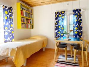 a bedroom with a bed and a table and a desk at Haikolan talo in Lipinlahti