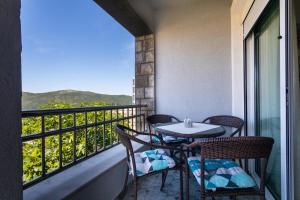 a balcony with a table and chairs and a window at Apartments Horizont in Budva