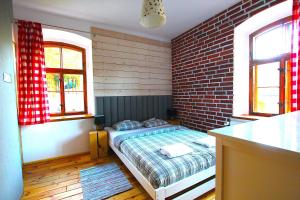 シュクラルスカ・ポレンバにあるBORSZÓWKA Dom Nad Potokiem - Pensjonatのレンガの壁、ベッド付きのベッドルーム1室