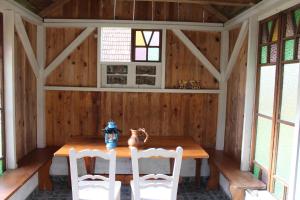 una sala da pranzo con tavolo in legno e 2 sedie di Sleeping in Village a Svečina