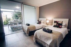 a bedroom with two beds and a balcony at 9 Kyalanga Beach in Durban +19 photos
