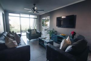 a living room with couches and a flat screen tv at 9 Kyalanga Beach in Durban