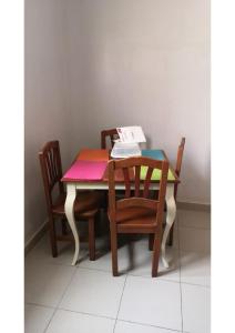 una mesa con sillas y un libro encima. en Résidence Fadi Diamniadio en Dakar