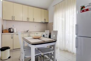 a kitchen with a table and chairs and a refrigerator at Apartments Horizont in Budva
