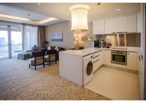 a kitchen and living room with a couch and a table at Dubai Mall Residences -Luxury 1 bedroom in Dubai