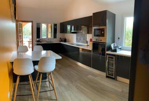 cocina con mesa blanca y sillas blancas en Villa Quatre Vents, en Punta Prima