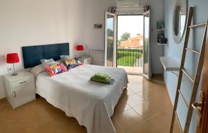 1 dormitorio con 1 cama y puerta a un balcón en Villa Quatre Vents, en Punta Prima 35 fotos más