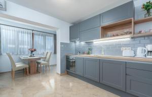 una cocina con armarios azules y una mesa con sillas en Apartments Villa Ana, en Poreč