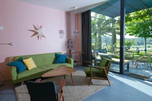 sala de estar con sofá verde y sillas en Bel Appart Style Vintage Vue Mer, en La Londe-les-Maures
