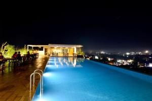 a swimming pool at night with a view of a city at Student Park 636 by We Stay in Yogyakarta