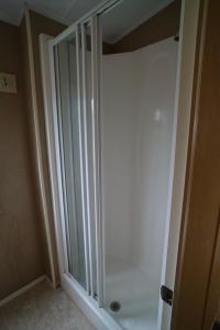 a shower stall in a bathroom with a glass door at The Manor at Manor Park Hunstanton with WiFi free pets in Hunstanton