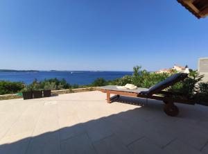 ムリニにあるApartments Vita - Modern apartments with a beautiful view of the Adriatic seaの水辺の景色を望むパティオ(ベンチ付)