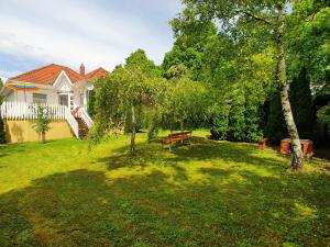 a yard with a bench and a house at Holiday House Filemon in Vonyarcvashegy