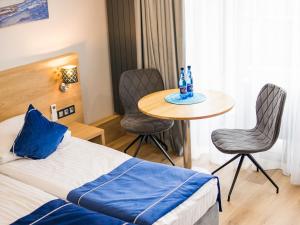 a hotel room with a bed and a table and chairs at Cobalt Apartments in Mikołajki