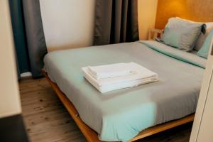 a bed with two white towels on top of it at Cabanas da Colina in Bombarral