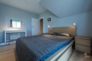 ein Schlafzimmer mit einem großen Bett mit blauen Wänden in der Unterkunft Rydzewo domek w zabudowie szeregowej nad jeziorem in Rydzewo