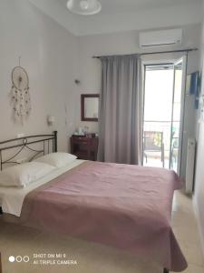 a bedroom with a bed with a pink blanket at Hotel Trifylia in Kyparissia