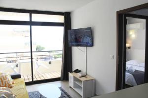- un salon avec un lit et une grande fenêtre dans l'établissement CosySeaside Corsica Ajaccio Piscine Terrasse Mer, à Ajaccio