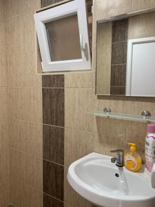 a bathroom with a sink and a mirror at Sunrise Apartments and Studios in Star Dojran