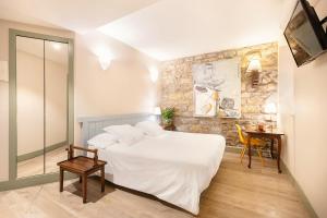 
a room with a bed, a chair, and a lamp at Hotel Okako San Sebastian in San Sebastián
