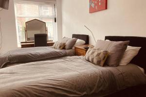 a bedroom with two beds and a mirror on the wall at 2 Beautiful Apartments in One House in Kidderminster