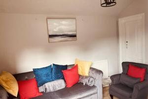 a living room with a couch and a chair at 2 Beautiful Apartments in One House in Kidderminster