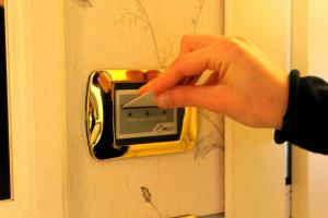 a person is unlocking a door with a clock at Hotel La Noce in Chivasso