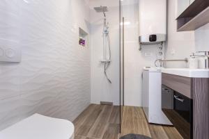 a bathroom with a shower and a toilet and a sink at Apartments Doris in Malinska