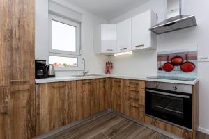 una cocina con armarios de madera y fregadero en Apartments Doris, en Malinska