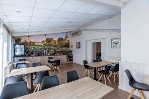 a restaurant with wooden tables and chairs and a counter at Logis Hôtel L'Oliveraie in Cognac