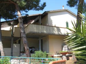 a white house with palm trees in front of it at Gli Oleandri in Capoliveri