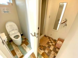 a small bathroom with a toilet and a mirror at CAMP＆COTTAGE THE DOOR in Fujikawaguchiko +34 photos