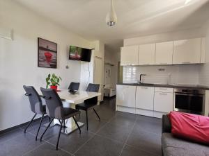 eine Küche und ein Wohnzimmer mit einem Tisch und Stühlen in der Unterkunft Apartment Adriana in Seget Vranjica