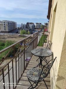 a table and chairs on a balcony with a view of the beach at ЖК Прибалтийский силуэт in Zelenogradsk