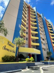 a building with a palm tree in front of it at Apartamento Thermas das Caldas Residencial in Caldas Novas
